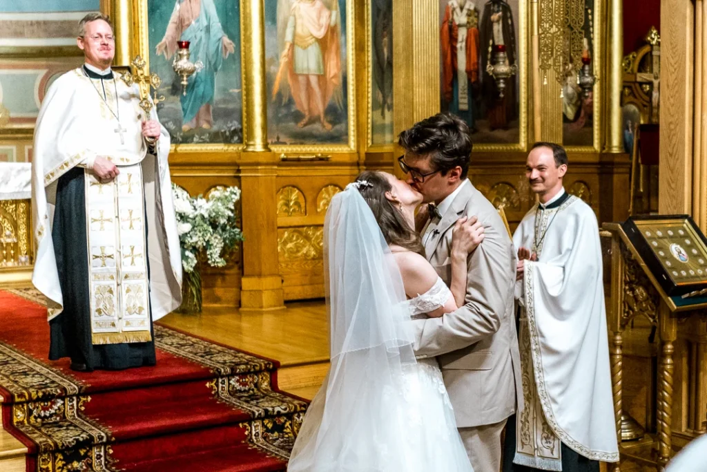 Bride and groom, embracing with a kiss first kiss as they are married