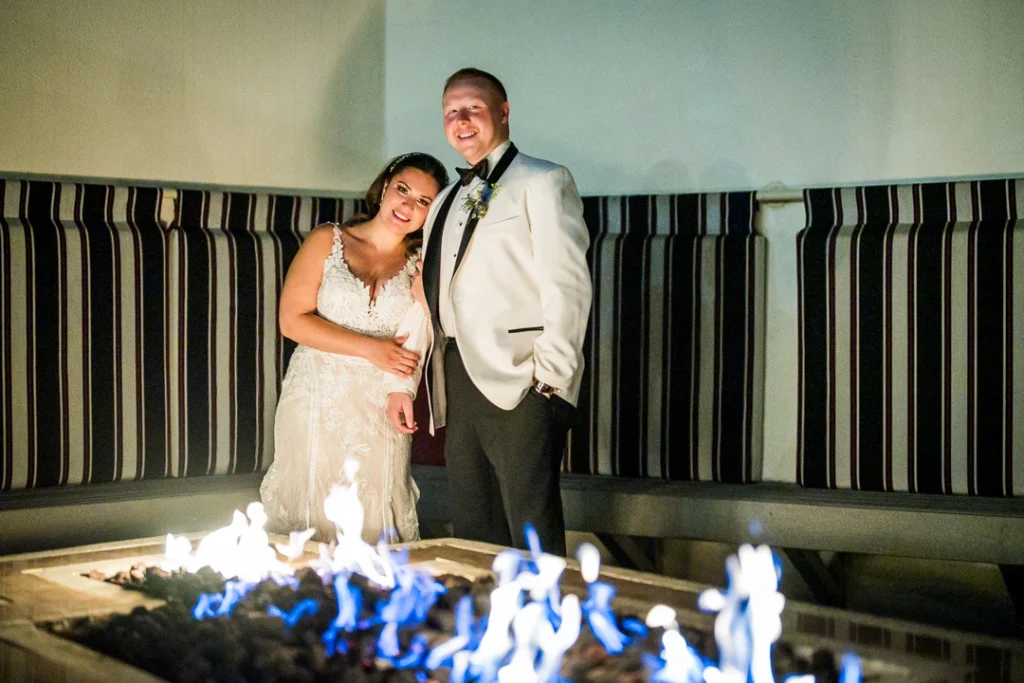 Bride and groom standing by the fire