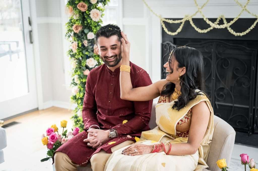 Laughter and Celebration: The bride shares a laugh with the groom, capturing a moment of joy and lightheartedness during the ceremony.