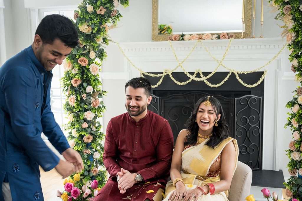 Bright Smiles: The bride and groom share a joyful moment, surrounded by family, showcasing the happiness of the occasion.
