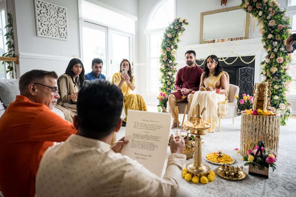 Ceremonial Reading: A family member reads from a traditional text, surrounded by other attendees, highlighting the cultural depth of the ceremony.