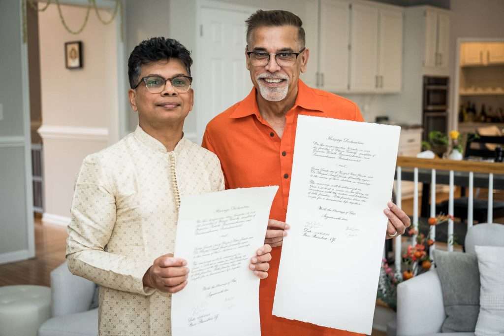 Two Men Holding Ceremony Invitations: Two distinguished gentlemen proudly display their personalized engagement ceremony invitations, reflecting the rich cultural heritage and deep personal significance of the occasion.