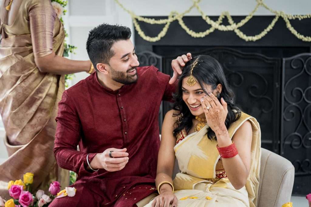 Playful and Affectionate Couple: A playful and affectionate scene unfolds during the engagement ceremony, showcasing the couple's joy and the intricate details of their traditional Indian attire.