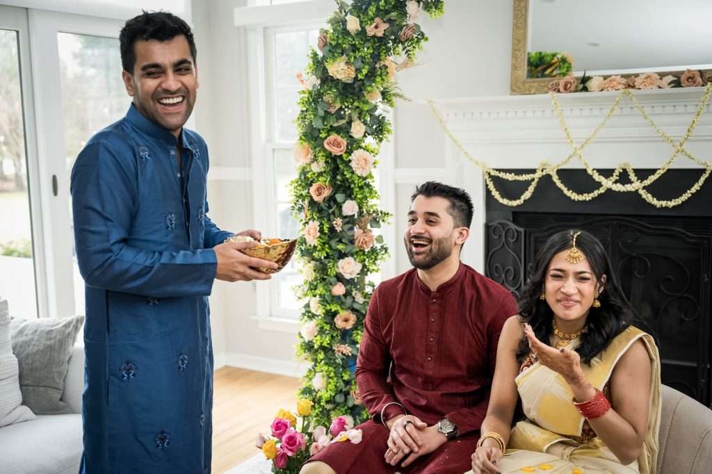 Joyful Family Interaction: A candid moment of laughter and joy during the engagement ceremony, highlighting the vibrant traditional attire and deep familial connections.