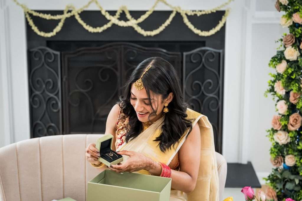 A captivating scene of the bride discovering her engagement gift, her joyful expression reflecting the surprise and delight of the moment surrounded by elegant decor.
