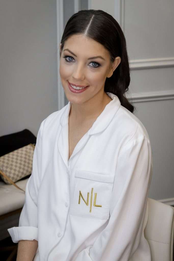 A bride sits elegantly in her bridal suite at The Rockleigh, smiling in anticipation of her big day