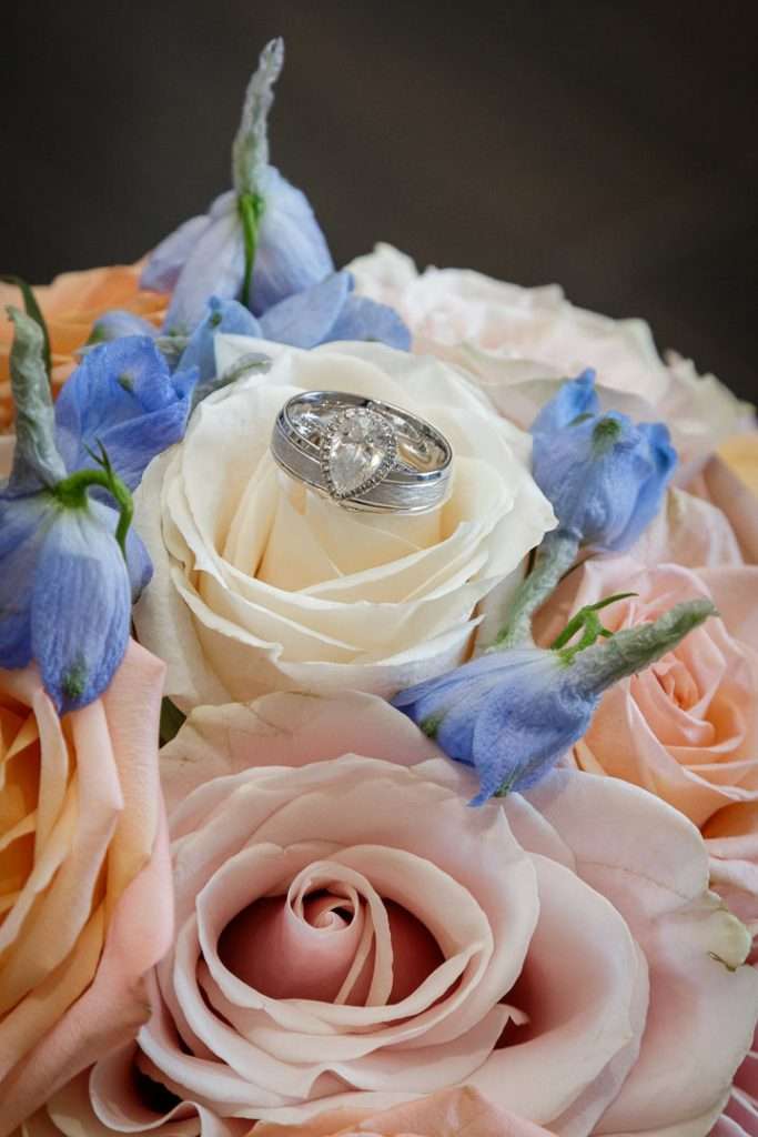  A pair of elegant wedding rings rest on a beautiful pastel bouquet at The Rockleigh.