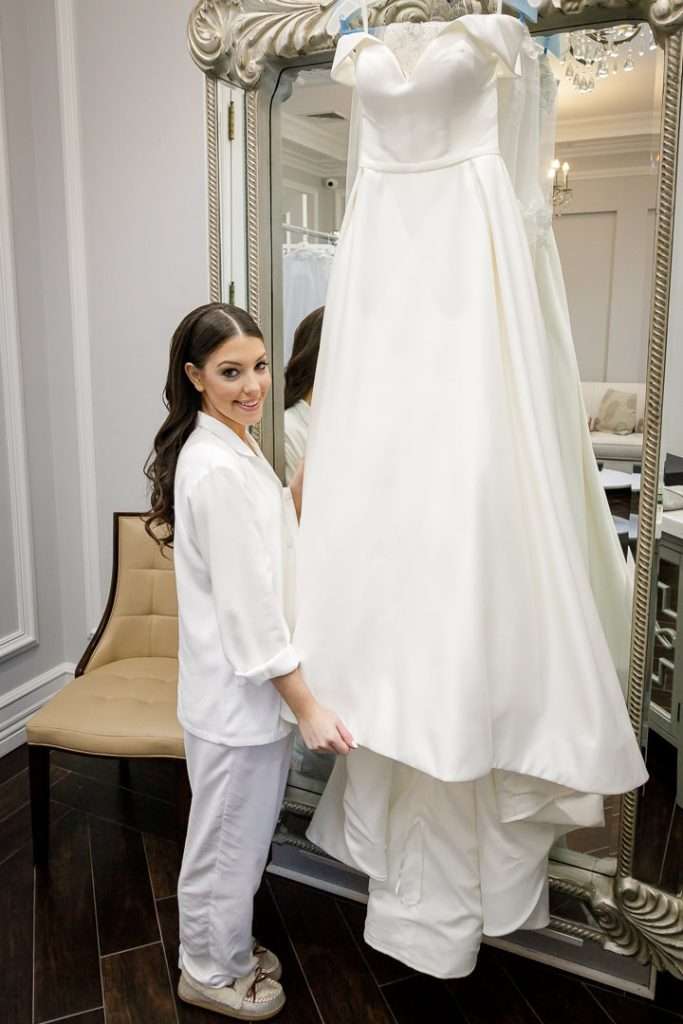 A bride admires her wedding gown, displayed in an elegant mirror at The Rockleigh bridal suite