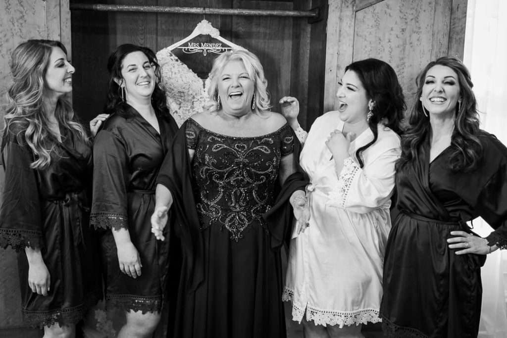 The bride, her mother, and bridesmaids share a joyful moment while getting ready for the wedding at The Park Savoy Estate.
