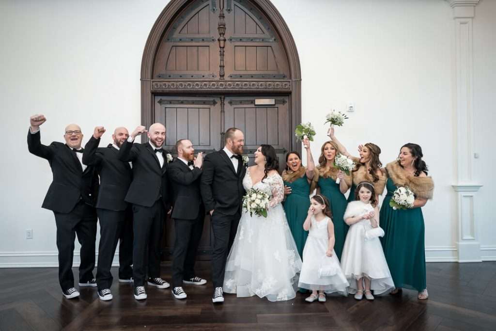 The wedding party, dressed in elegant attire, cheers and celebrates inside The Park Savoy Estate.