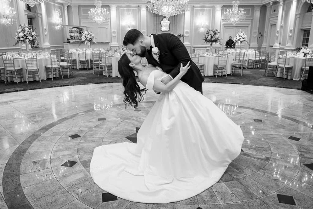 A black-and-white image of the bride and groom’s romantic first dance dip in The Rockleigh ballroom.