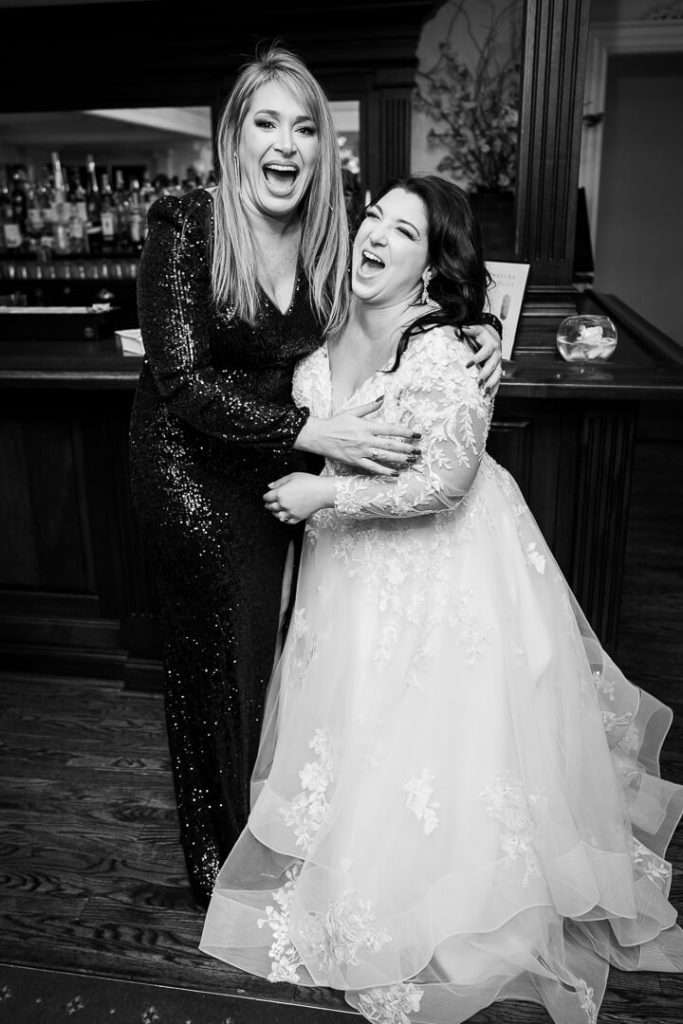 Bride and her friend burst into laughter at the bar inside The Park Savoy, capturing a joyful wedding moment.