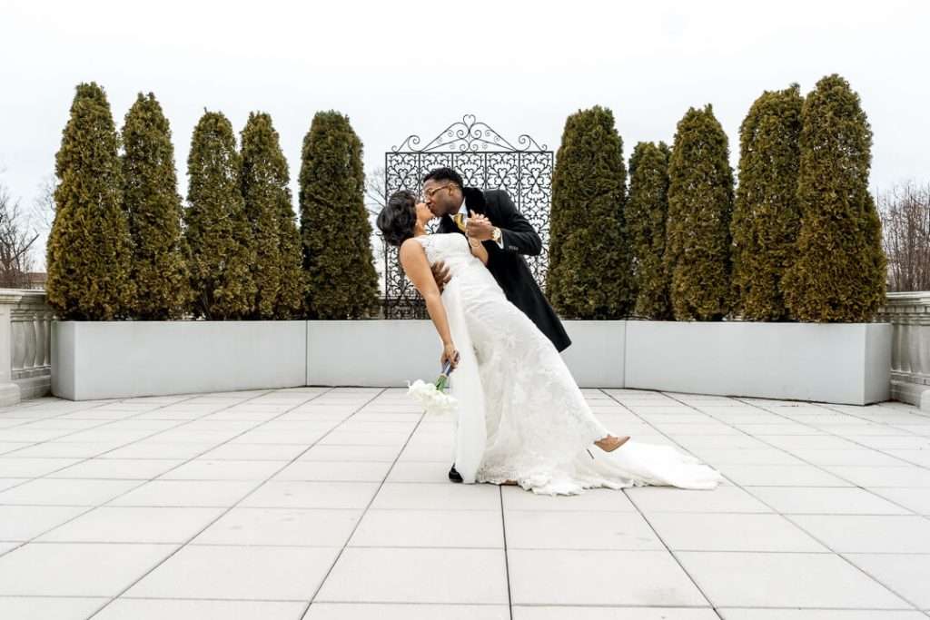 Elegant wedding dip at The Palace at Somerset Park – The groom dips his bride in a romantic pose on the terrace of The Palace at Somerset Park, showcasing the venue’s elegant outdoor setting.