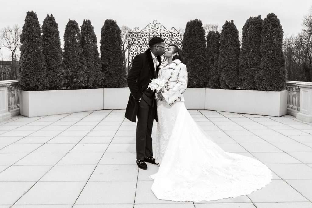 Black and white wedding portrait at The Palace at Somerset Park – A timeless black and white image of the couple sharing a kiss against the beautifully landscaped backdrop.