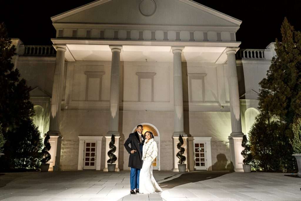 Nighttime wedding portrait at The Palace at Somerset Park – The couple poses in front of the grand entrance of the venue, beautifully lit against the night sky.