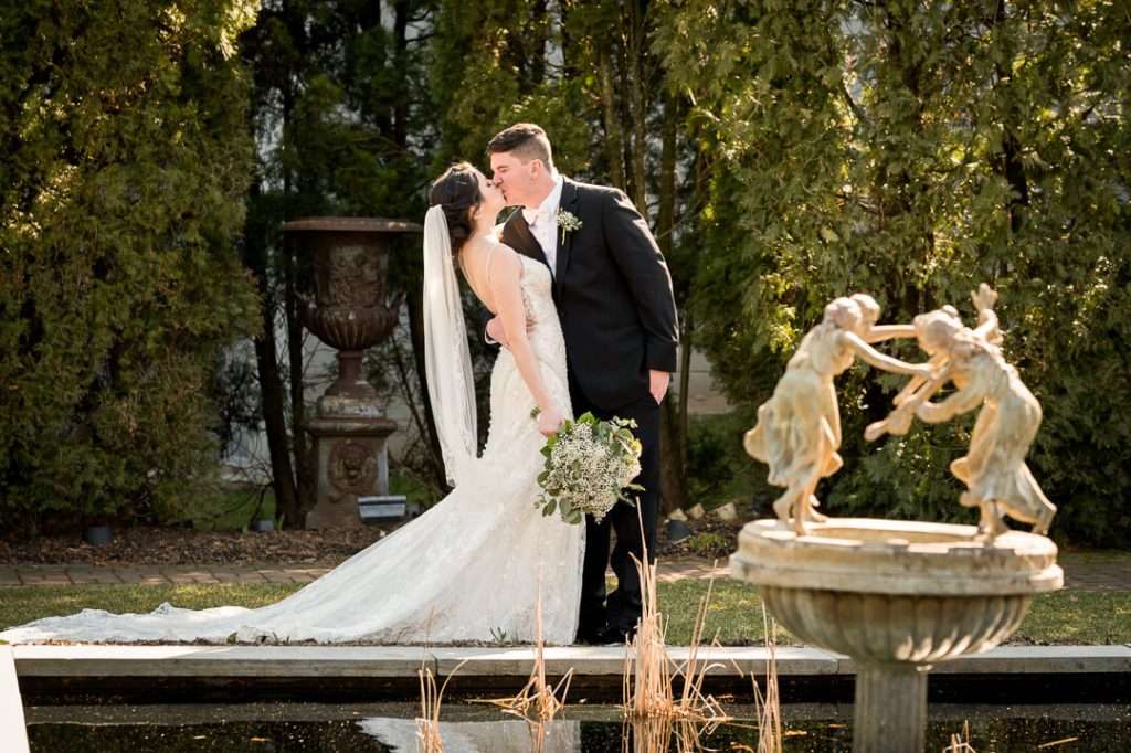 Newlyweds embrace near the garden fountain at Park Savoy wedding