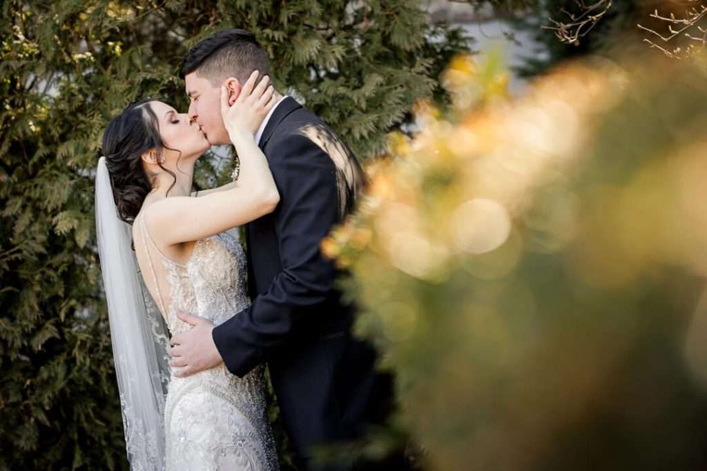 Bride and groom share an intimate moment surrounded by greenery at Park Savoy