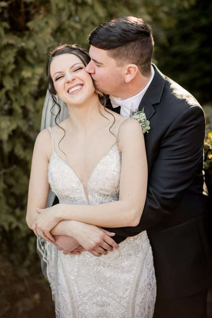 Bride and groom stand together in front of elegant stone wall at Park Savoy