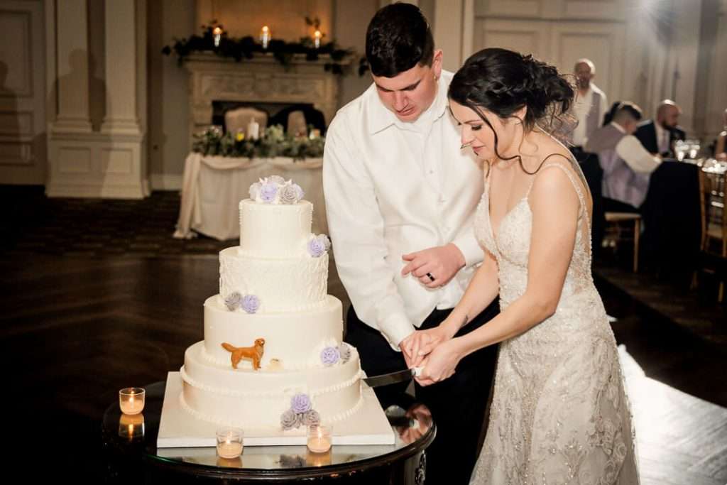 Bride and groom share a sweet kiss while cutting their wedding cake at Park Savoy