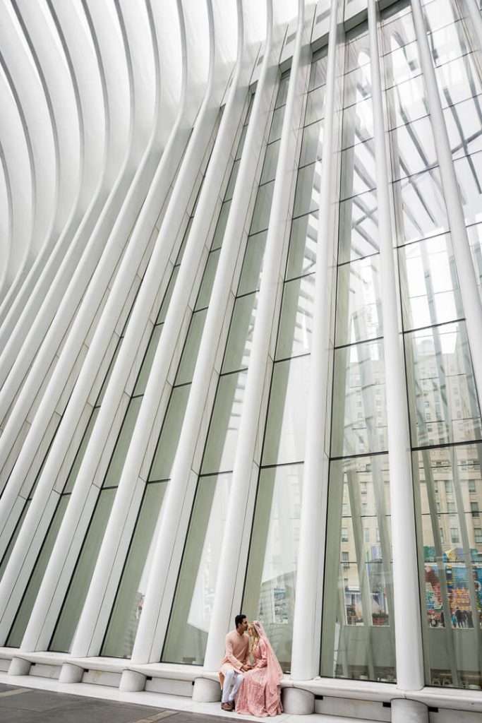 Wide-angle engagement portrait showcasing modern architecture at the Oculus NYC.