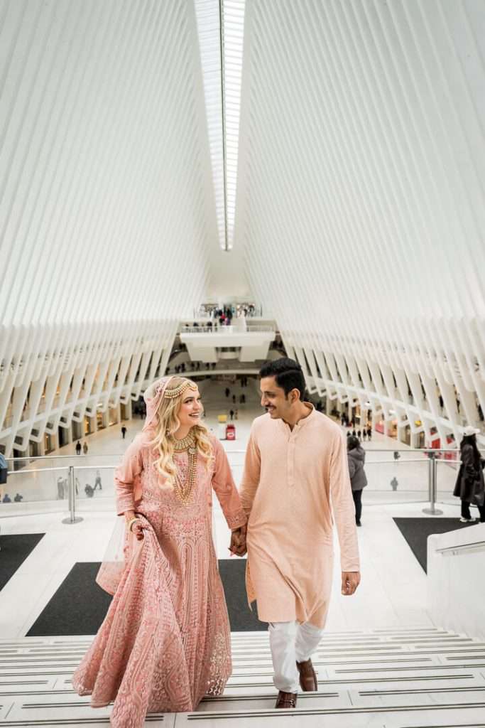 Couple walking up the stairs during an engagement session at the Oculus in NYC