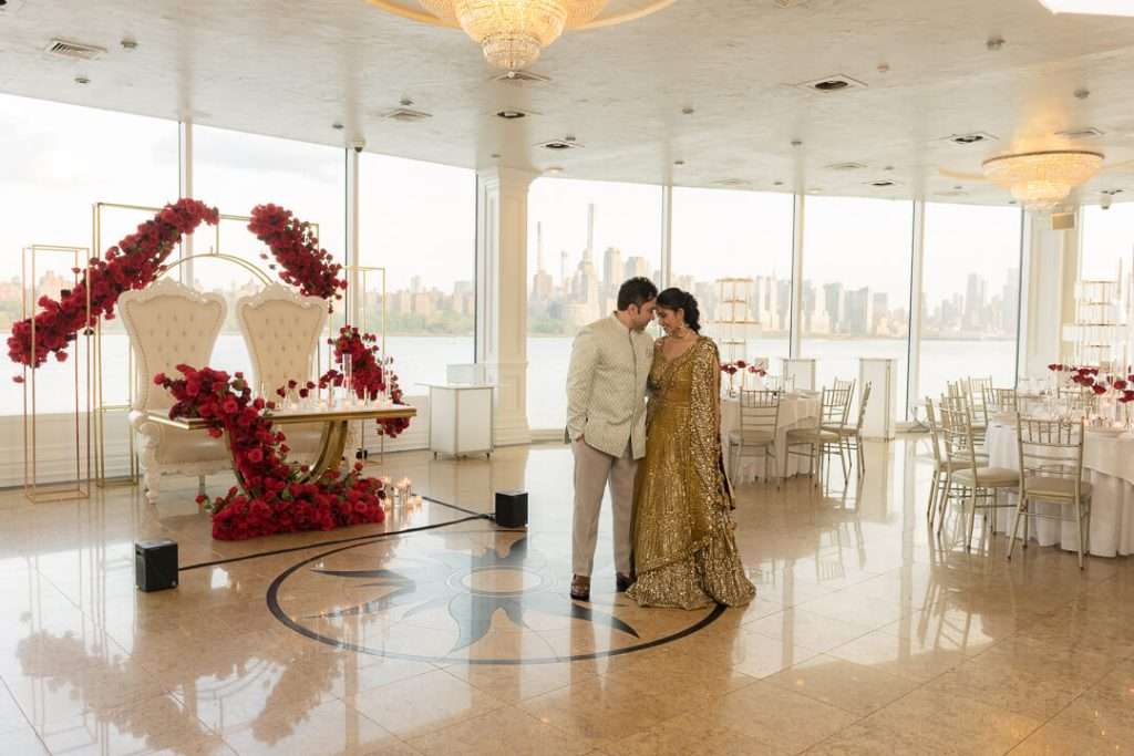 Reception hall at Waterside Restaurant NJ decorated with floral arrangements and uplighting for Sameer and Arohi’s wedding