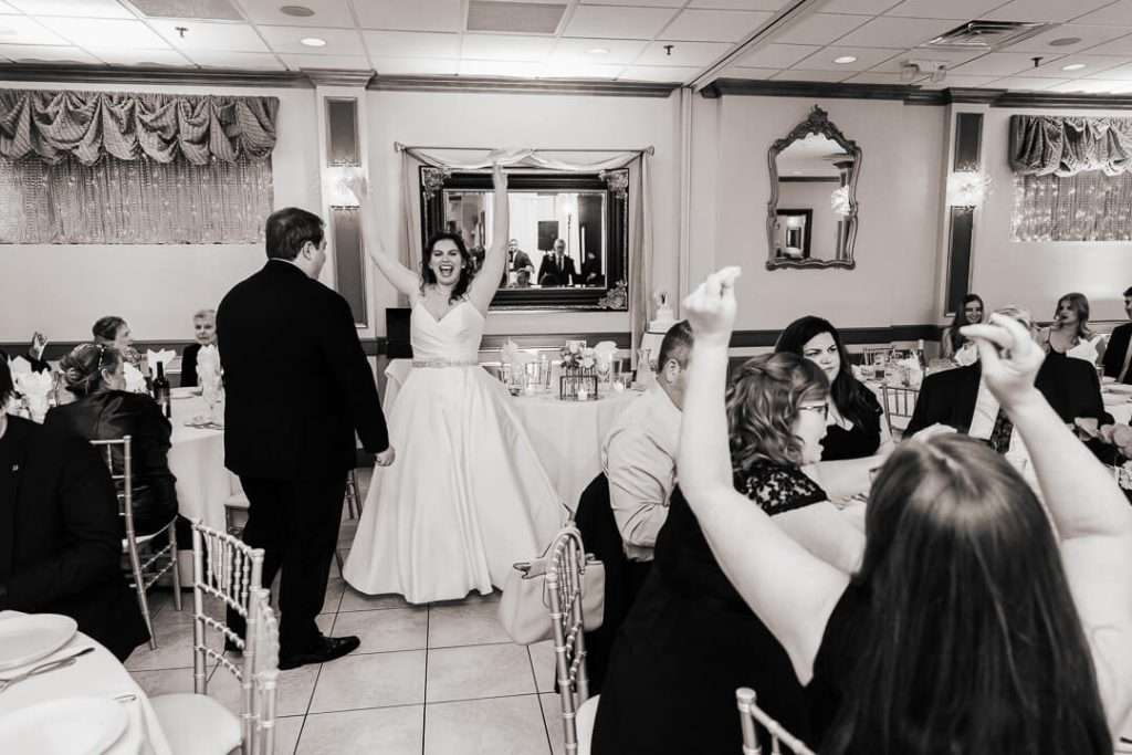 Bride cheering with arms raised during fun reception entrance at Nutley, NJ wedding