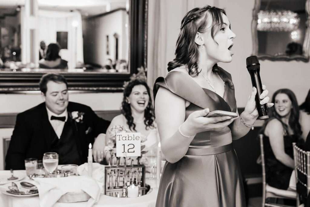 Maid of honor giving a toast as bride and groom laugh during reception at Mamma Vittoria Catering in Nutley, NJ