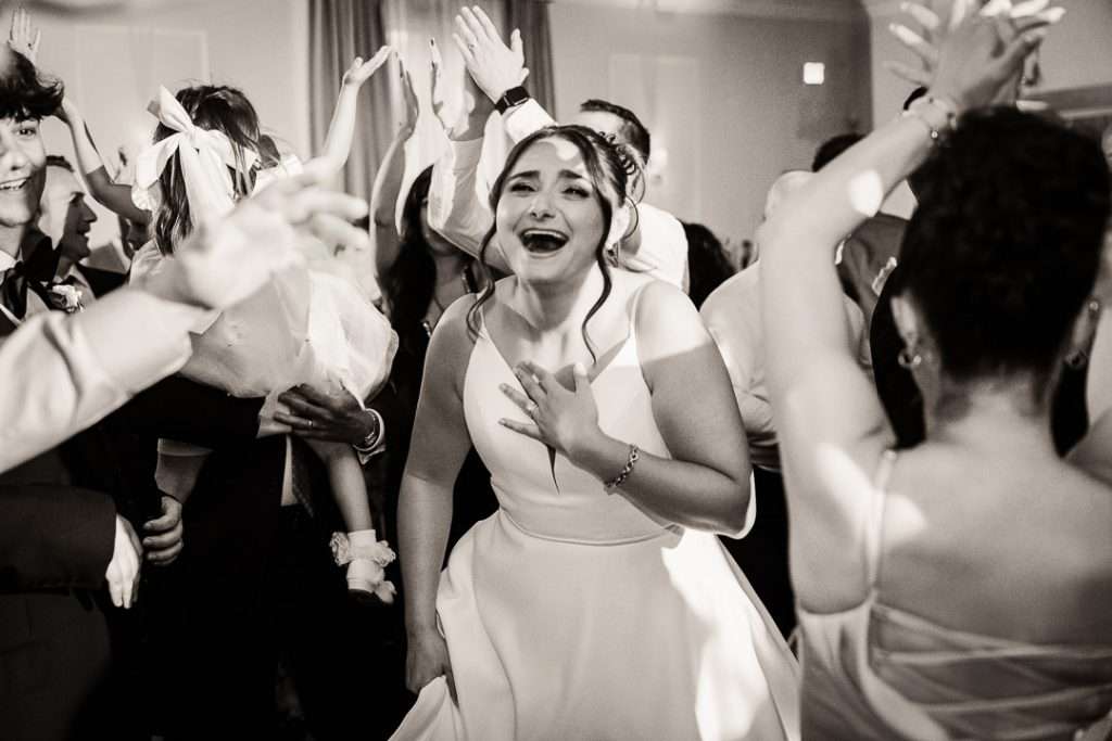 Bride and groom celebrating on the dance floor surrounded by guests at NJ wedding reception

