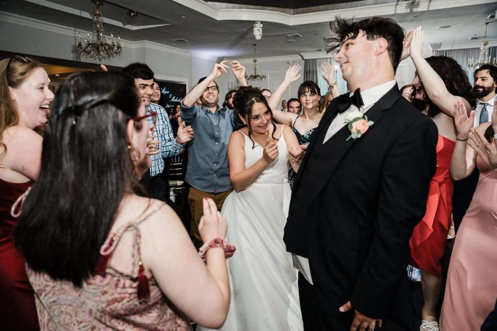 Wedding guests dancing with oversized face cutouts at lively NJ reception

