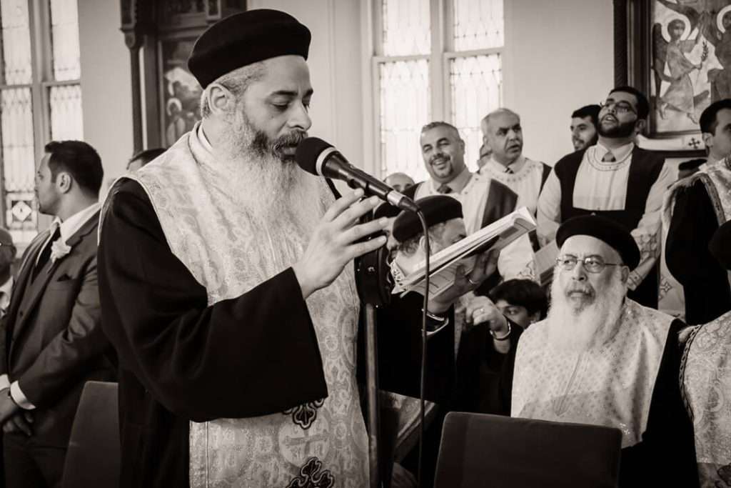 Coptic Orthodox priest reading scripture during wedding ceremony in NJ church
