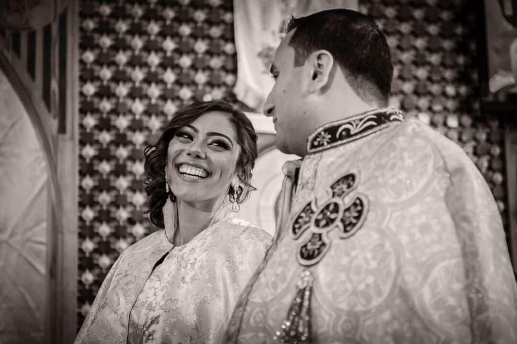Bride smiling at groom during Coptic Orthodox wedding ceremony in New Jersey