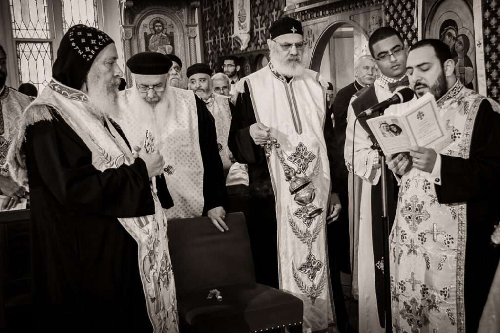 Coptic Orthodox clergy performing sacred wedding rituals at altar in NJ church