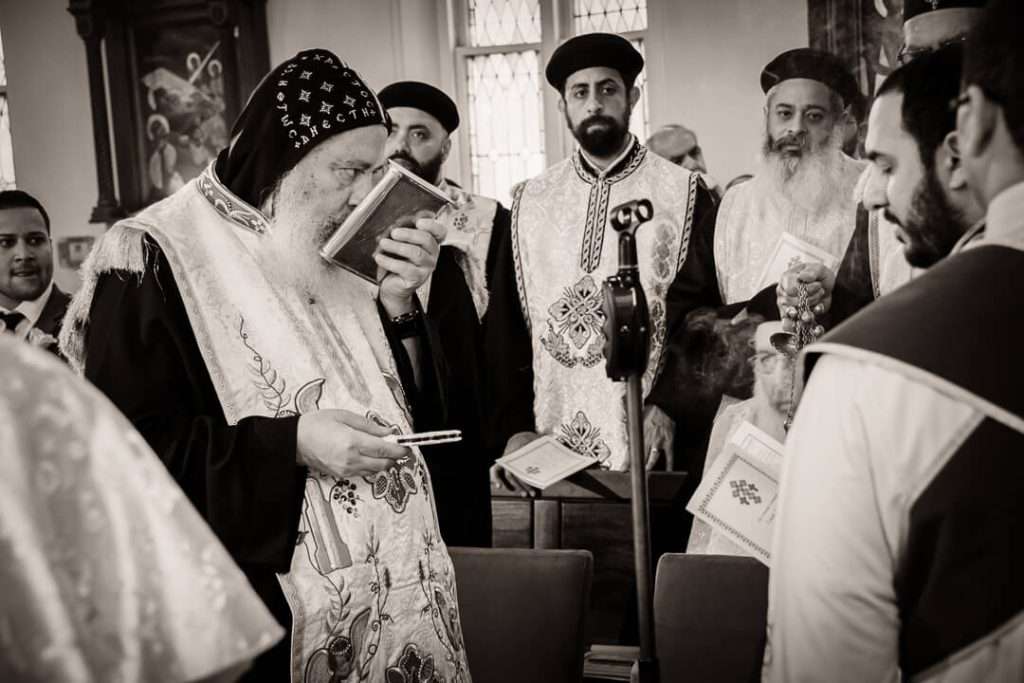 Coptic Orthodox bishop kissing the Bible during traditional wedding liturgy in NJ