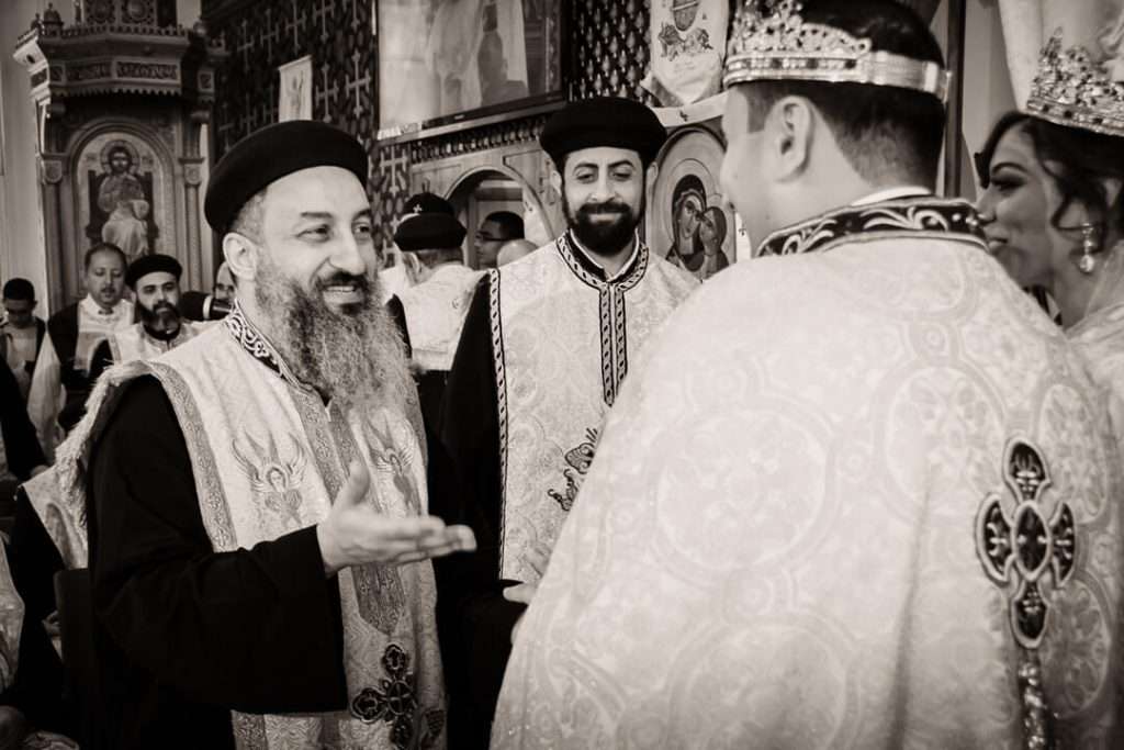 Coptic priest offering a blessing to newlywed couple during wedding ceremony in New Jersey