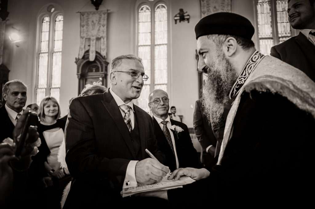  Father of the bride signing official marriage document at Coptic Orthodox wedding