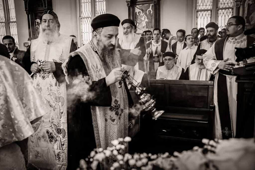 Coptic priest offering a blessing to newlywed couple during wedding ceremony in New Jersey