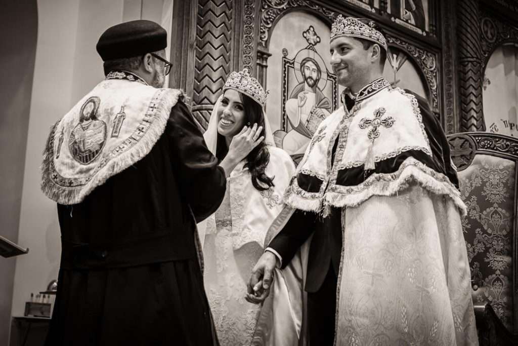Coptic priest anointing bride during sacred wedding ceremony in a New Jersey church