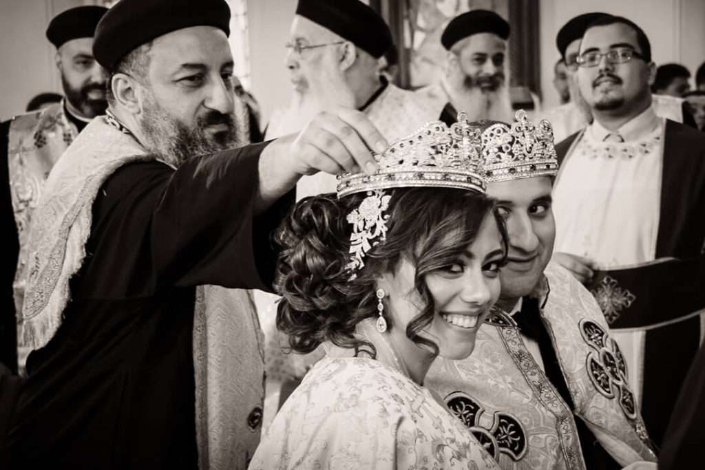 Coptic priest anointing bride during sacred wedding ceremony in a New Jersey church