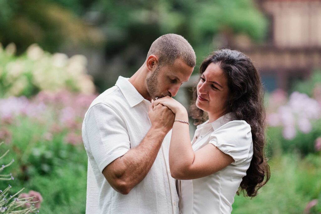 Man kissing his fiancee's hand after proposing at Van Vleck House and Gardens in Montclair NJ