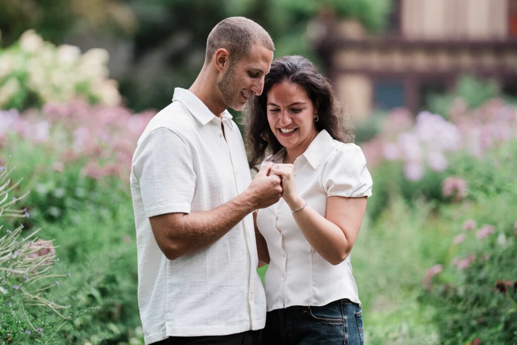 Newly engaged couple looking down at her ring at Van Vleck House Gardens in Montclair NJ