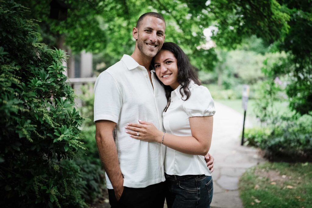 Newly engaged couple standing together on a shaded garden path at Van Vleck House Montclair NJ