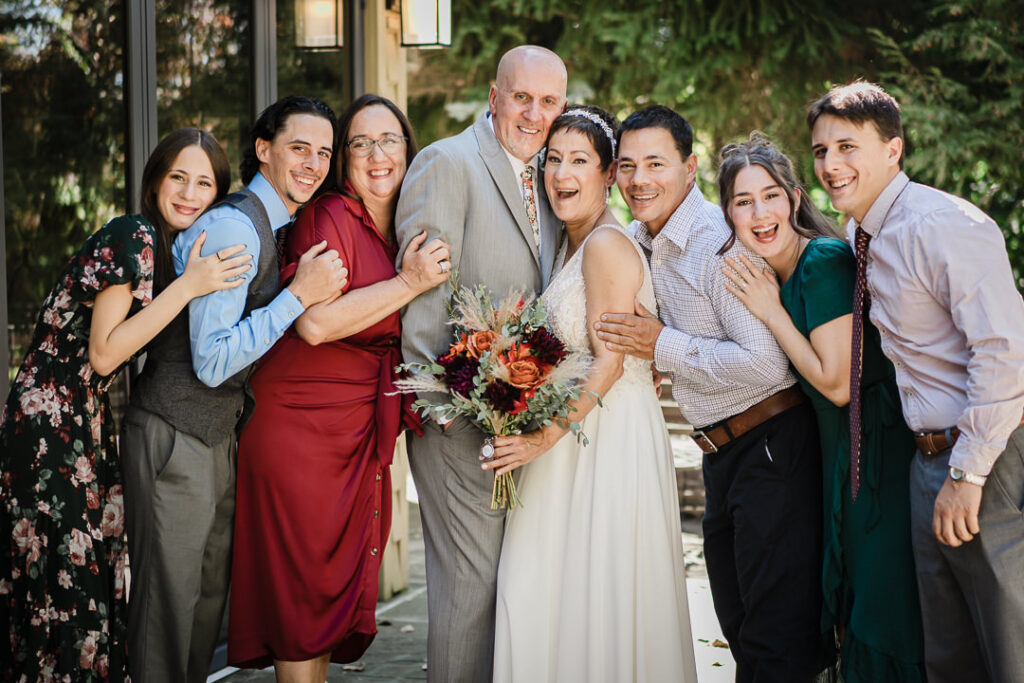 Bride and groom surrounded by family members during group portraits at Mohawk House in Sparta NJ.