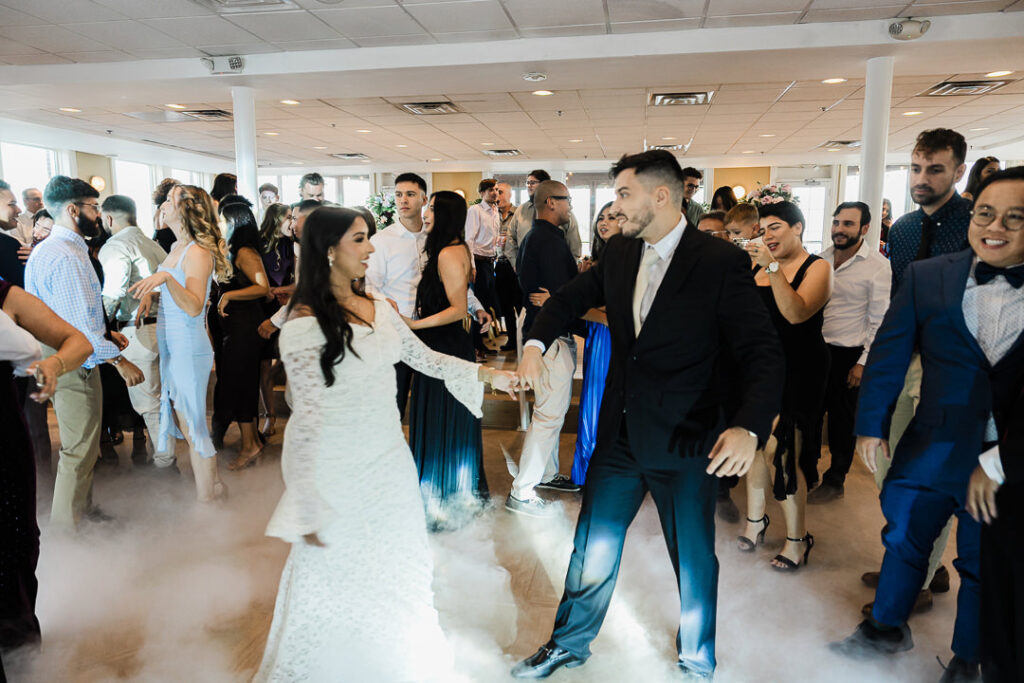 Bride and groom dancing surrounded by guests on the dance floor at The Armory NJ Restaurant in Perth Amboy, photographed by Alex Kaplan Photography.
