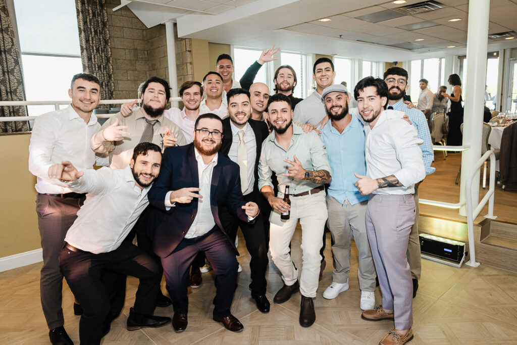 Groom celebrating with friends and guests during wedding reception at The Armory NJ Restaurant in Perth Amboy, photographed by Alex Kaplan Photography.