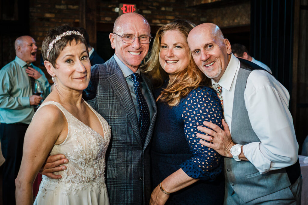 Bride and groom posing with family and friends during Mohawk House reception in Sparta NJ.