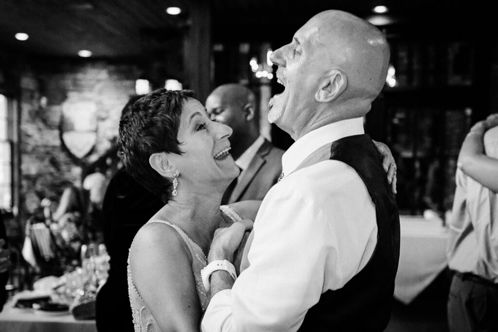 Black and white photo of the couple laughing together on the dance floor at Mohawk House.