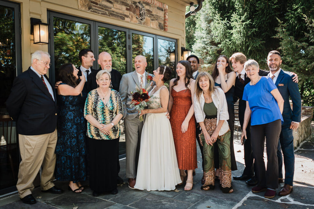 Family group portrait outdoors at Mohawk House after the ceremony, surrounded by fall greenery.
