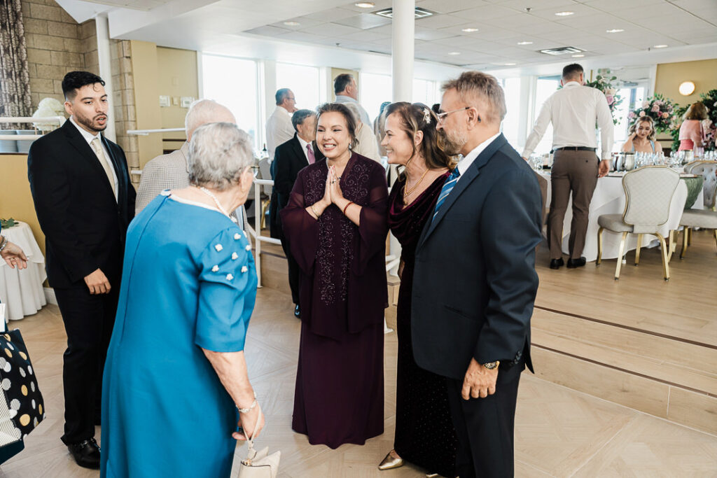 Joyful family moment as guests greet one another and share laughter during an engagement celebration at The Armory NJ Restaurant in Perth Amboy, captured by Alex Kaplan Photography.