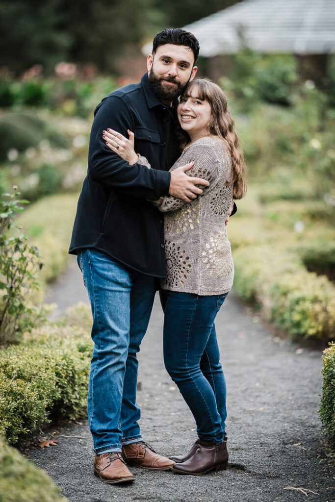 Couple embracing on garden pathway celebrating engagement at Deep Cut Gardens Middletown - NJ engagement session
